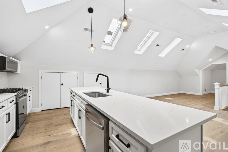 A kitchen with white cabinets and a marble countertop.