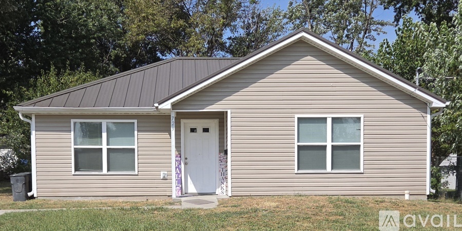 A small house with a brown roof and a white door.