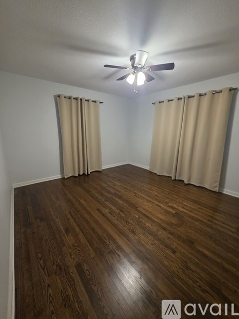 A room with wooden flooring and a ceiling fan.