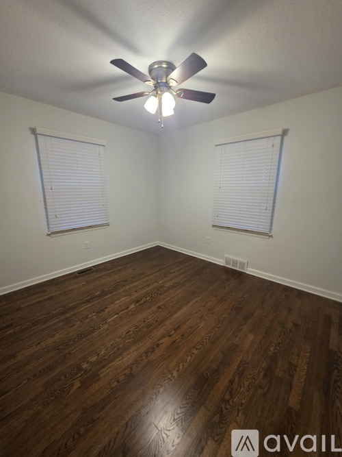 A room with wooden floors and a ceiling fan.