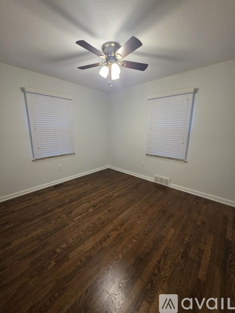 A room with wooden floors and a ceiling fan.