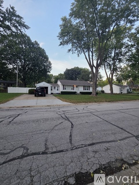 A white house with a driveway in front of it.