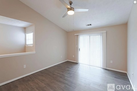 A room with wooden flooring and a ceiling fan.