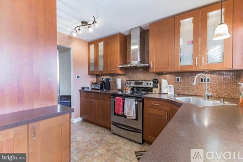A kitchen with wooden cabinets and a tiled backsplash.
