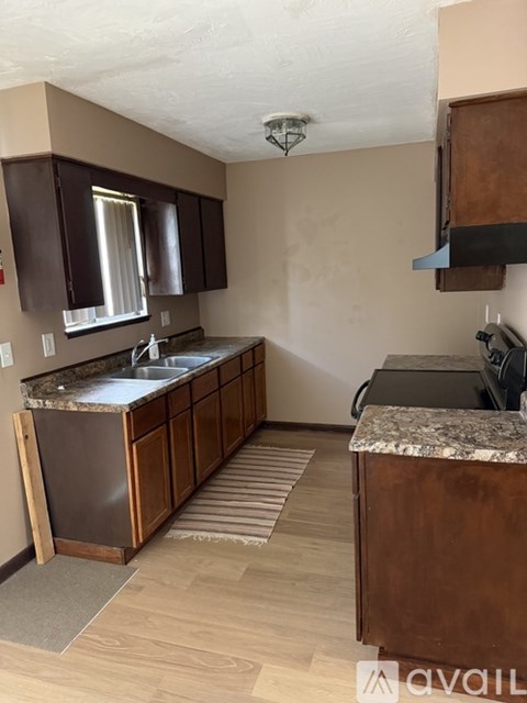 A kitchen with brown cabinets and a granite countertop.