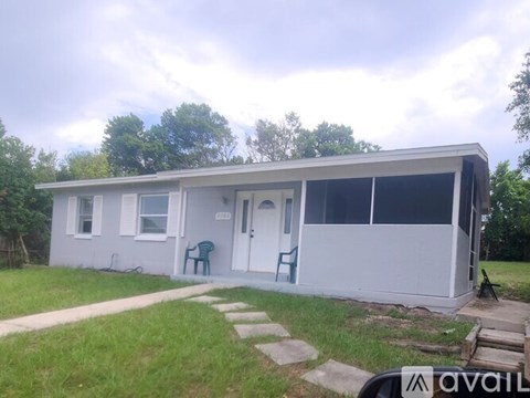 A white mobile home with a green chair outside.