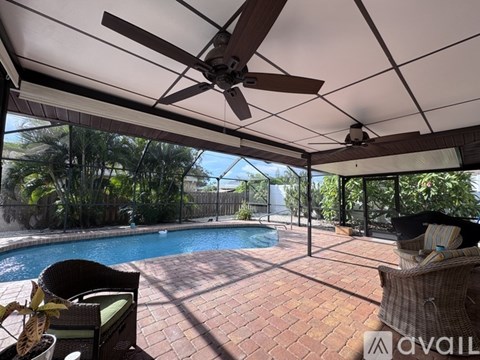 A patio with a pool and a ceiling fan.