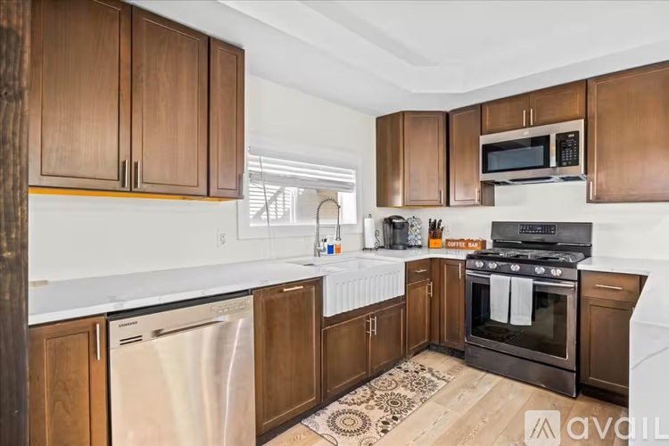 A kitchen with wooden cabinets and a black stove top oven.