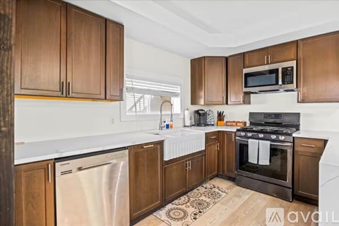 A kitchen with wooden cabinets and a black stove top oven.