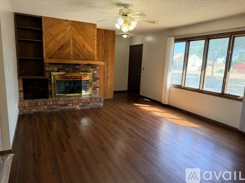 A living room with wood floors and a fireplace.