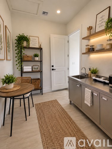 A kitchen with a table, chairs, and a plant on the shelf.