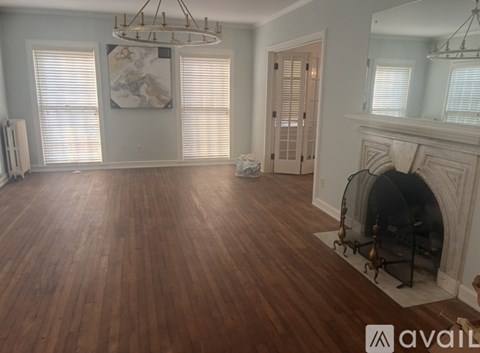 A large room with wood floors and a fireplace.
