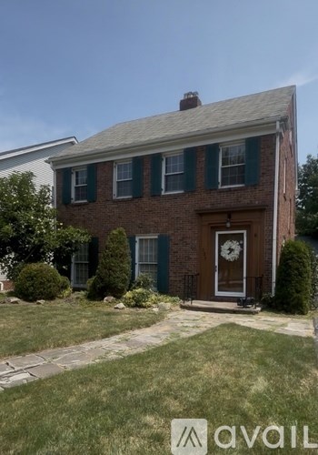 A brick house with a green lawn in front.