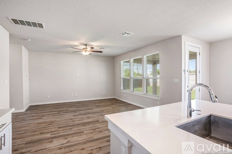 A kitchen with a sink, counter, and a window.