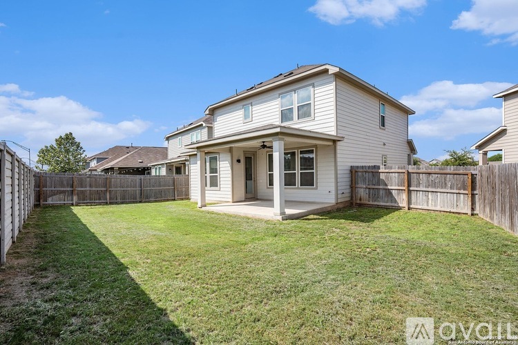 A house with a fence and a green lawn in front.