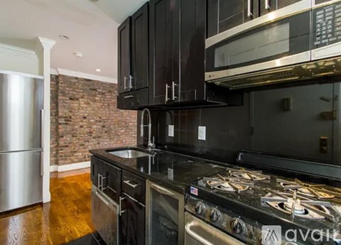 A kitchen with black cabinets and a stove top oven.