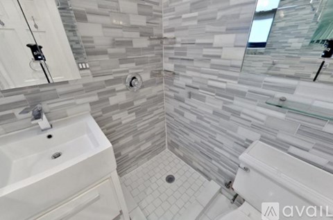 A bathroom with a white sink and a glass shower stall.