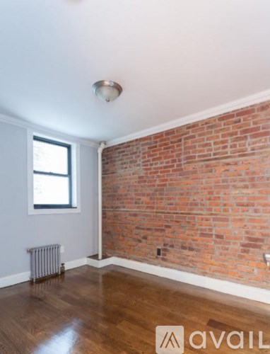 A room with a brick wall and wooden flooring.