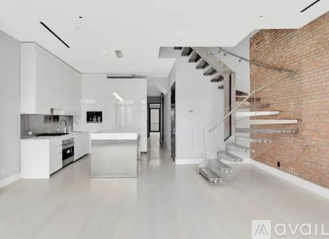A modern kitchen with white cabinets and a brick wall.