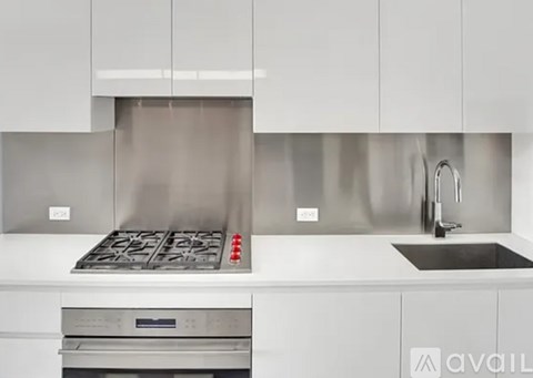 A modern kitchen with a stainless steel range hood and a stainless steel oven.
