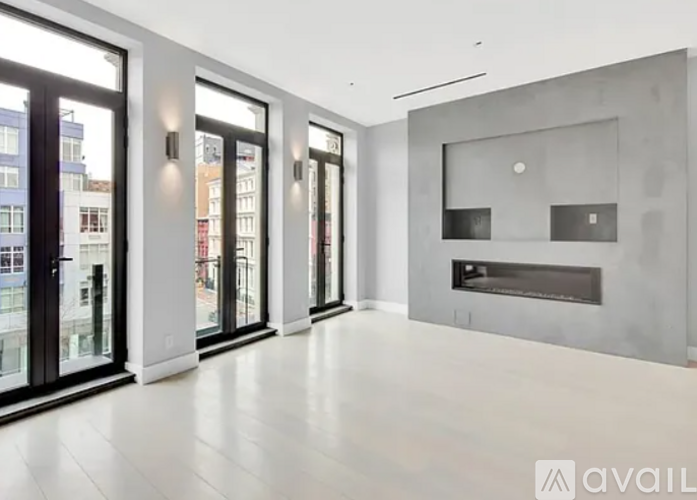 A spacious room with a fireplace and large windows.