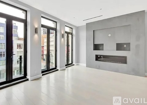 A spacious room with a fireplace and large windows.