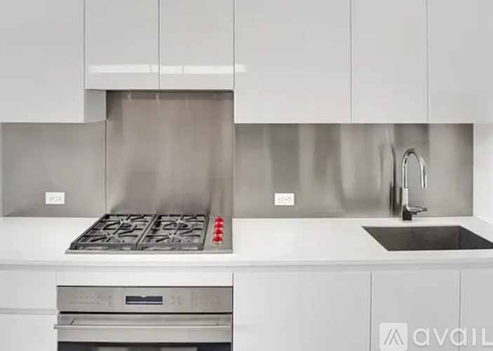 A modern kitchen with a stainless steel range hood and a stainless steel oven.