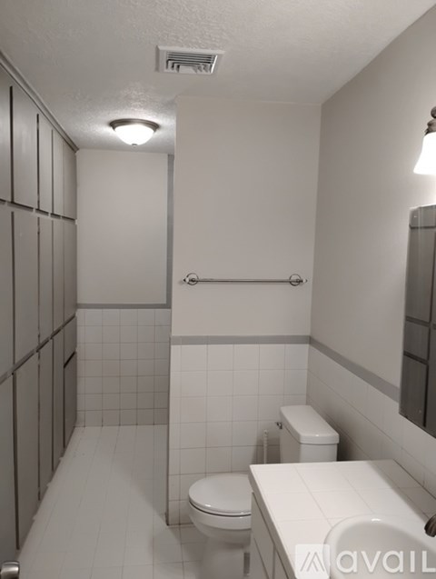 A white bathroom with a toilet, sink, and shower.