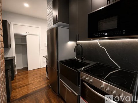 A modern kitchen with a stainless steel refrigerator and oven.