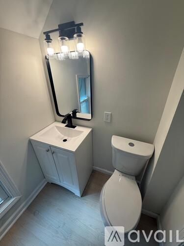 A bathroom with a sink, toilet and mirror.