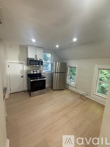 A kitchen with a refrigerator, stove, and microwave.