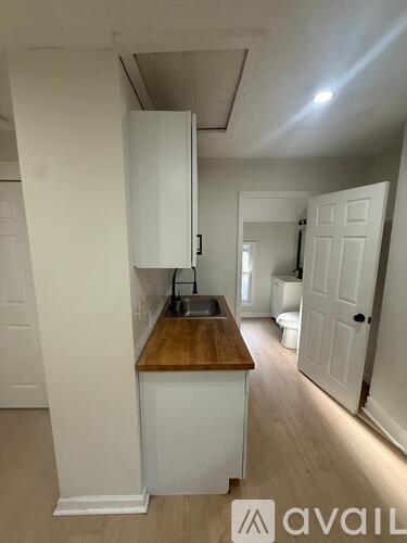 A kitchen with white cabinets and a wooden countertop.