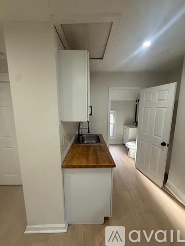 A kitchen with white cabinets and a wooden countertop.
