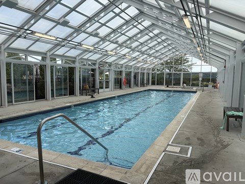 A large indoor swimming pool with a glass ceiling.
