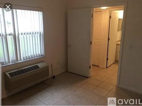 A room with a window and a white door.