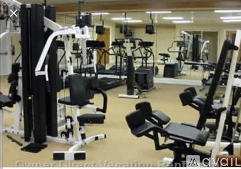 A gym with various exercise machines and weights.
