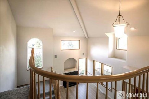 A well-lit interior of a house with a spiral staircase.
