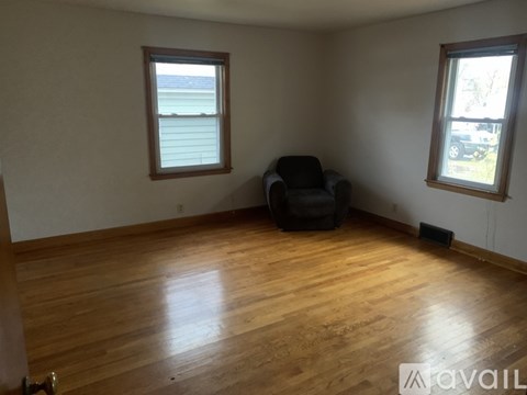 A room with wooden floors and a black chair.