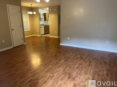 A room with wooden flooring and a white door.