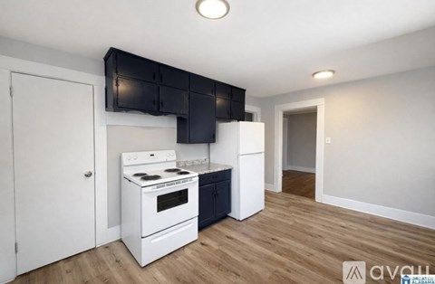 A kitchen with a white stove and black cabinets.