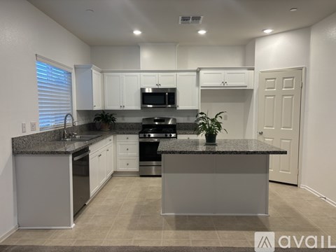A kitchen with granite countertops and white cabinets.
