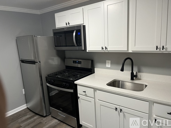 A kitchen with white cabinets and a stainless steel refrigerator.