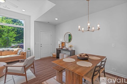 A modern dining room with a wooden table and chairs.