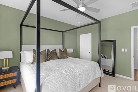 A bedroom with a four poster bed and a mirror on the wall.