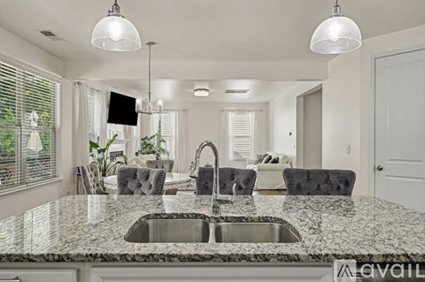 A modern kitchen with granite countertops and a central island.