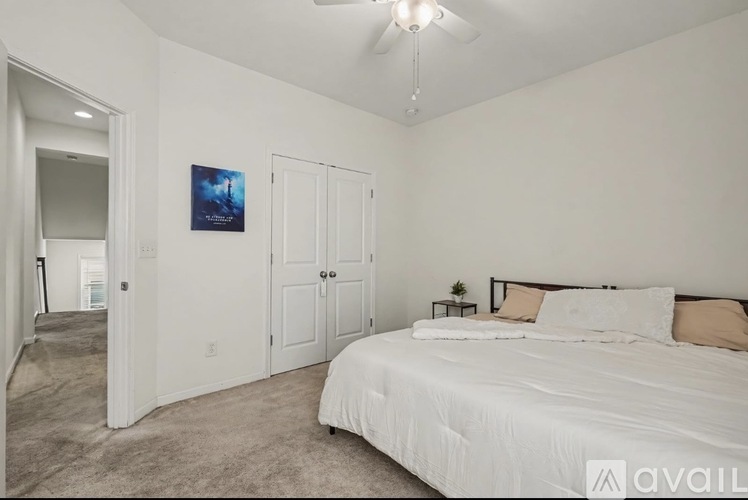 A bedroom with a large bed and a ceiling fan.