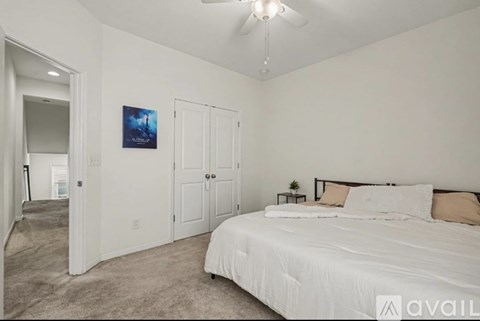 A bedroom with a large bed and a ceiling fan.