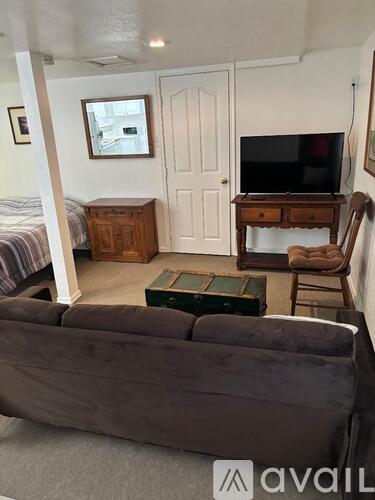 A living room with a grey couch and a wooden cabinet.