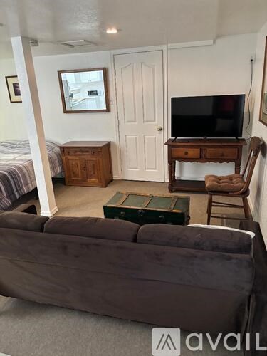A living room with a grey couch and a wooden cabinet.