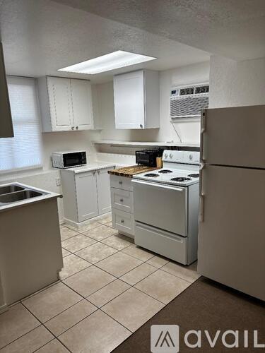 A kitchen with white cabinets and appliances is on the market.